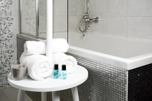 een badkamer met een witte wastafel en een witte tafel met handdoeken bij Vinyl Apartment Old Town in Krakau