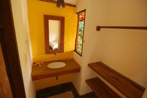y baño con lavabo y espejo. en Pousada Tortuga, en Barra Grande