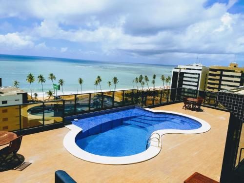 a view of a swimming pool on a building with the beach at Port Ville III in Maceió