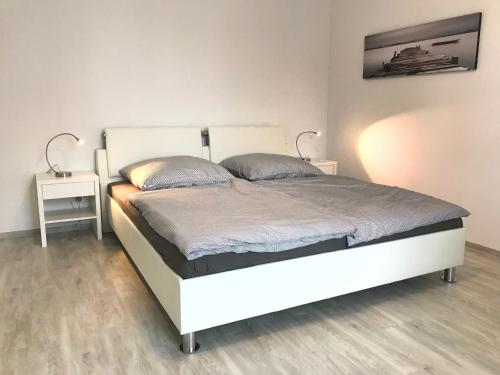 ヴァーネミュンデにあるApartment Warnemünde 14のベッドルーム1室(白いベッド1台、ランプ2つ付)