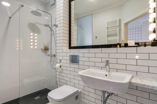 W łazience znajduje się umywalka, toaleta i lustro. w obiekcie 5 pokoi w Gdańsku