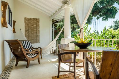 a dining room with a table and chairs on a porch at Santa Teresa Hotel Rio de Janeiro - MGallery Collection in Rio de Janeiro