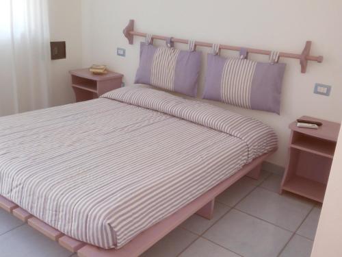 a bedroom with a large bed with purple pillows at B&B Conca del Faro in Mattinata