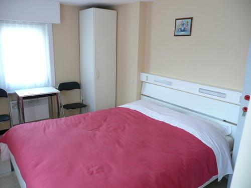 um quarto com uma cama com um cobertor rosa em De Windroos em Pollinkhove