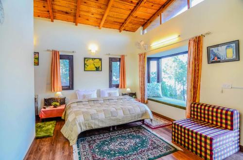 een slaapkamer met een bed, een bank en een raam bij Hostie Sharanam - 2BHK Pvt Mountain Villa, Majkhali in Rānīkhet