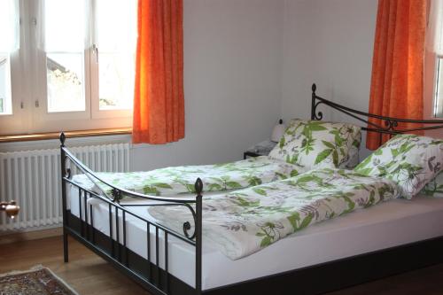 a bedroom with a bed with green and white sheets at B&B Stirnimann in Bunzen