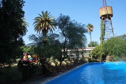 una piscina en el complejo con una torre de agua en el fondo en El Solar de Belén en Belén de Escobar