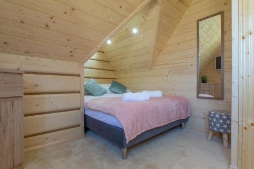 a bedroom in a log cabin with a bed at Domek z widokiem-Deluxe Cottage with a View Deluxe-Zakopane in Zakopane