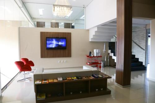 a living room with a tv on a wall at Premium Palace Hotel in Ariquemes