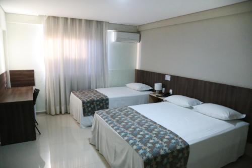 Habitación de hotel con 2 camas y ventana en Premium Palace Hotel, en Ariquemes
