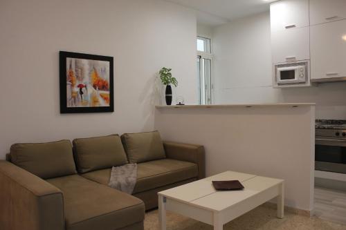 a living room with a couch and a coffee table at Apartamento Alfaqueque in Seville