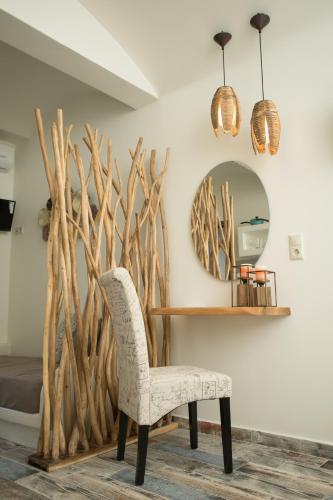 a room with a chair and a mirror at Naxos Petite Studios in Agios Prokopios