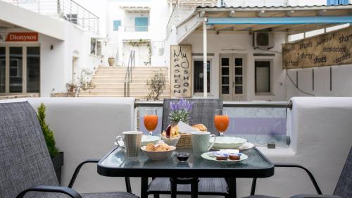 stół z jedzeniem i napojami na balkonie w obiekcie Naxos Petite Studios w miejscowości Agios Prokopios