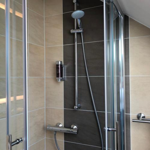 a shower with a glass door in a bathroom at Hotel Select Suites & Aparts in Mönchengladbach