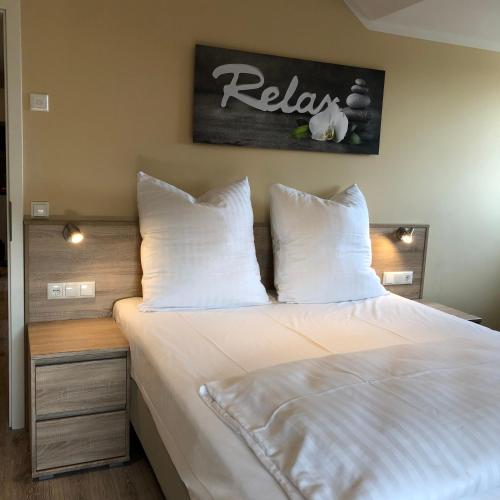 a bedroom with a bed with white sheets and pillows at Hotel Select Suites & Aparts in Mönchengladbach