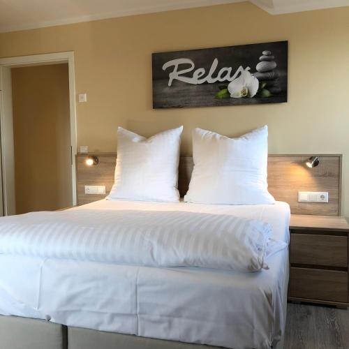 a bedroom with a large bed with white sheets and pillows at Hotel Select Suites & Aparts in Mönchengladbach