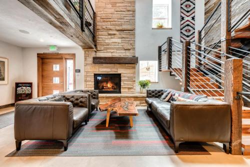 uma sala de estar com mobiliário de couro e uma lareira em A-Lodge Boulder em Boulder