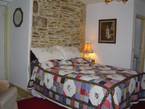 1 dormitorio con 1 cama con pared de ladrillo en Holdstrong Farmhouse, en Lydford