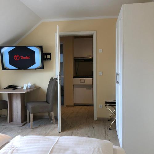 a room with a bed and a table and a television at Hotel Select Suites & Aparts in Mönchengladbach