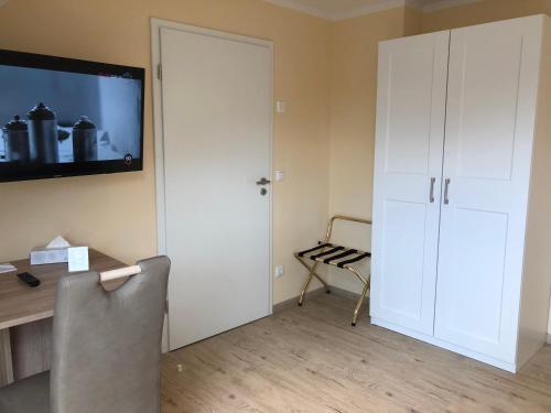 a room with a desk and a television on a wall at Hotel Select Suites & Aparts in Mönchengladbach