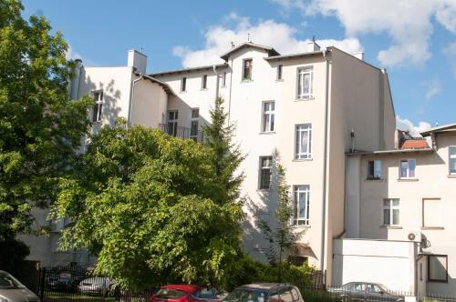 un edificio blanco con coches estacionados frente a él en Pokoje Sopockie en Sopot