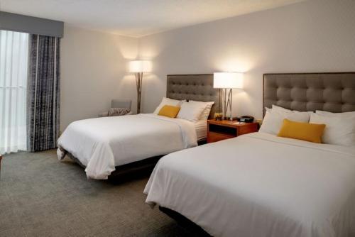 a hotel room with two beds and two lamps at The Kensington Hotel in Ann Arbor