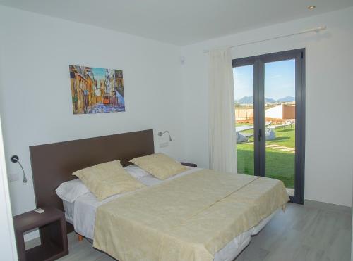 ムロにあるVilla Adriaのベッドルーム1室(ベッド1台、大きな窓付)