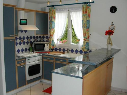 a kitchen with a sink and a stove top oven at Gîte Dieppe in Auppegard