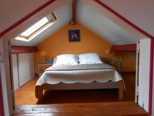 een slaapkamer met een bed op zolder bij Gîte Dieppe in Auppegard