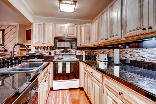a kitchen with wooden cabinets and black counter tops at The Forest Neighborhood by Keystone Resort in Keystone