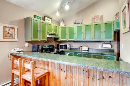 a kitchen with green cabinets and a counter at The Forest Neighborhood by Keystone Resort in Keystone