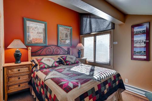 a bedroom with orange walls and a bed and a window at The Forest Neighborhood by Keystone Resort in Keystone