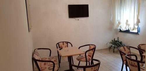 Cette chambre dispose d'une table, de chaises et d'une télévision. dans l'établissement Hotel Basilea, à Bellaria-Igea Marina