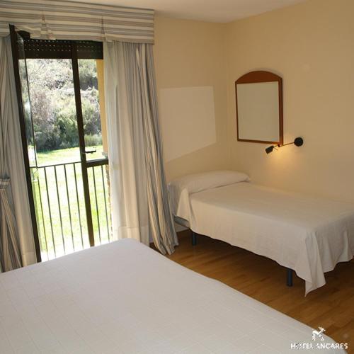 sypialnia z 2 łóżkami i oknem z widokiem w obiekcie Ancares w mieście Balboa