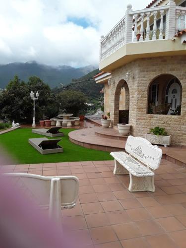 a patio with two white benches in front of a building at Holiday Home Hemi in Valsequillo