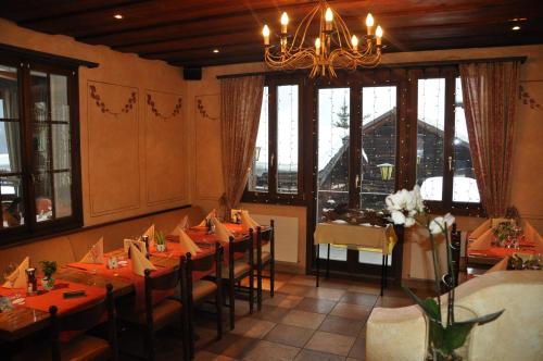 a dining room with tables and chairs and a chandelier at Hotel Spinne Grindelwald in Grindelwald