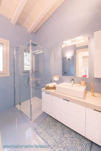 a bathroom with a glass shower and a sink at Antica Fonte Holiday Homes in San Pantaleo
