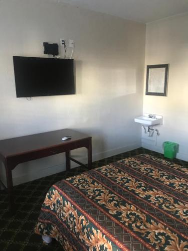 ein Hotelzimmer mit einem Bett und einem Waschbecken in der Unterkunft Hotel West Inn, Hollywood - LA in Los Angeles