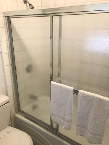 a bathroom with a shower with two white towels at Hotel West Inn, Hollywood - LA in Los Angeles