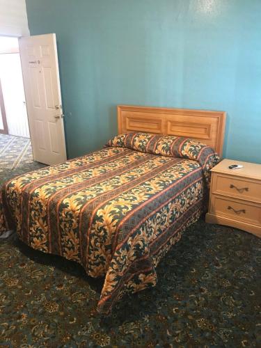 a bedroom with a bed and a dresser in it at Hotel West Inn, Hollywood - LA in Los Angeles