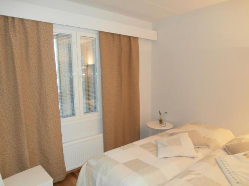1 dormitorio con cama y ventana en Huoneistohotelli Nallisuites, en Oulu
