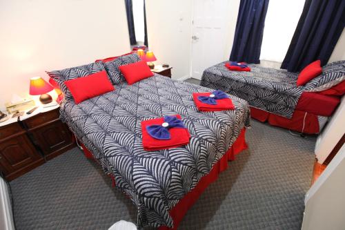 a hotel room with two beds and two nightstands at Jacaranda Guest House in Busselton
