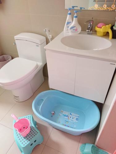 a bathroom with a toilet and a sink and a tub at The Railroad Runs in Taitung City