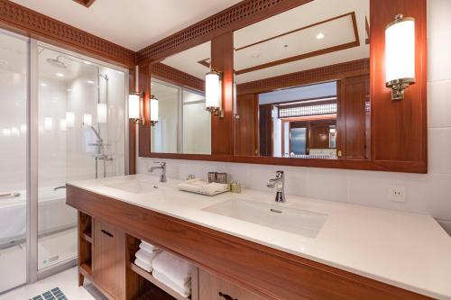 a bathroom with two sinks and a mirror at Premier Hotel Mojiko in Kitakyushu
