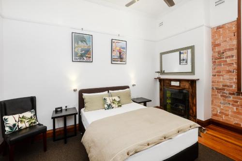 Pier Hotel Coffs Harbour في كوفس هاربور: غرفة نوم بسرير ومدفأة