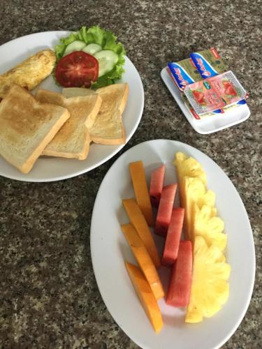 dos platos de comida con frutas y verduras. en Cat Ba Eco Lodge, en Cat Ba