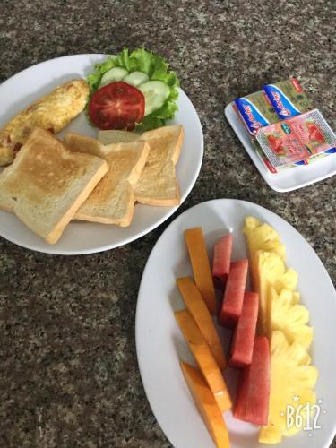Dos platos de comida con pan y verduras encima. en Cat Ba Eco Lodge, en Cat Ba