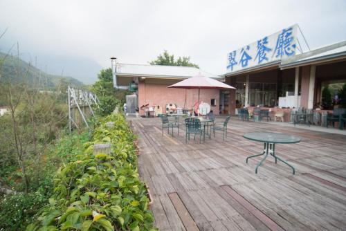 eine Terrasse mit einem Tisch und Stühlen sowie ein Gebäude in der Unterkunft 翠谷山莊Cui Gu Villiage in Lugu