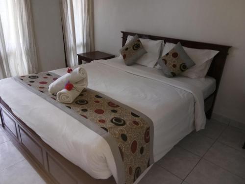a bedroom with two beds with white sheets and pillows at Reynold Artha Guest House in Nusa Lembongan