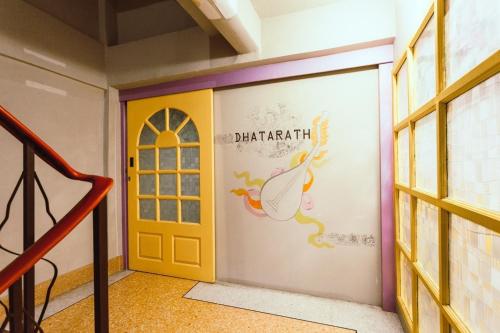 a door in a room with a wall with a peacock painted on it at Stash in Bangkok